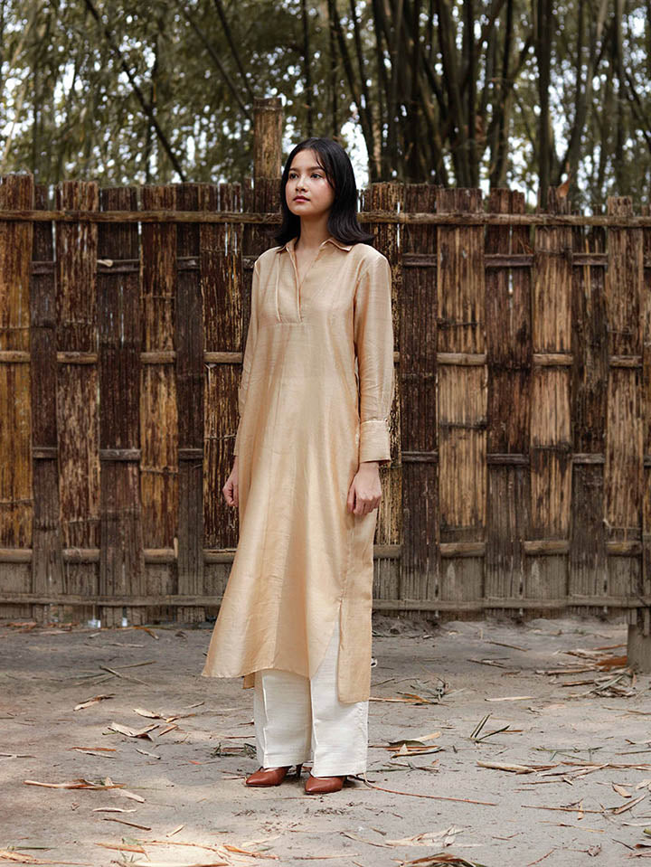 Long v neck slip-on gold-beige easy shirt with box pleat at back & asymmetrical hem, Relaxed Fit, Shell Buttons, Tea dyed Handwoven Chanderi Silk fabric.