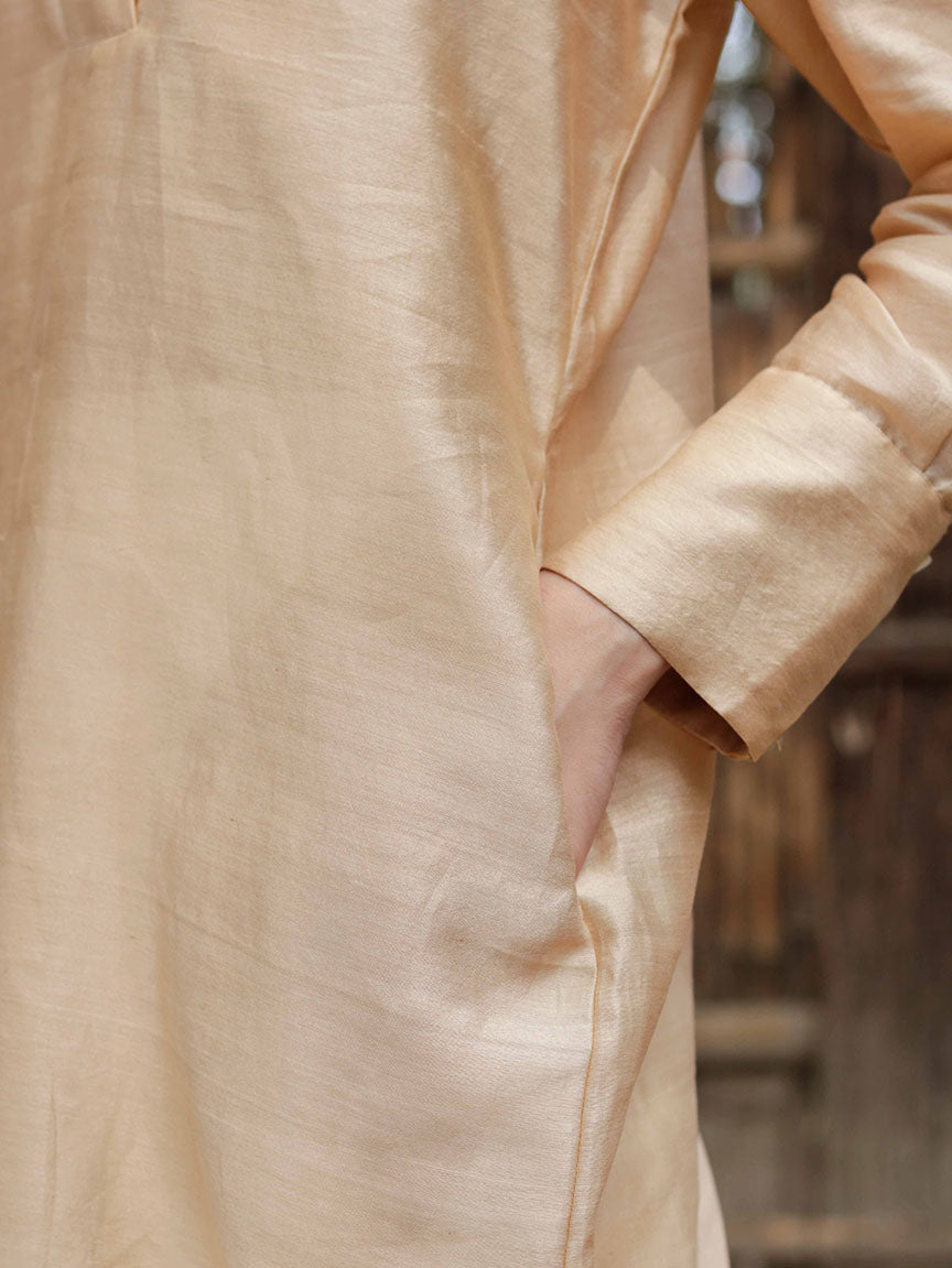 Long slip-on gold-beige easy shirt with box pleat at back & asymmetrical hem, Relaxed Fit, Shell Buttons, Tea dyed Handwoven Chanderi Silk fabric.
