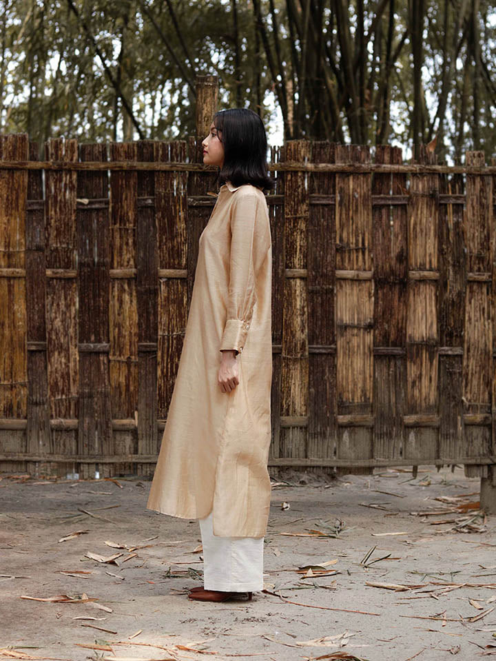 Long slip-on gold-beige easy shirt with box pleat at back & asymmetrical hem, Relaxed Fit, Shell Buttons, Tea dyed Handwoven Chanderi Silk fabric.