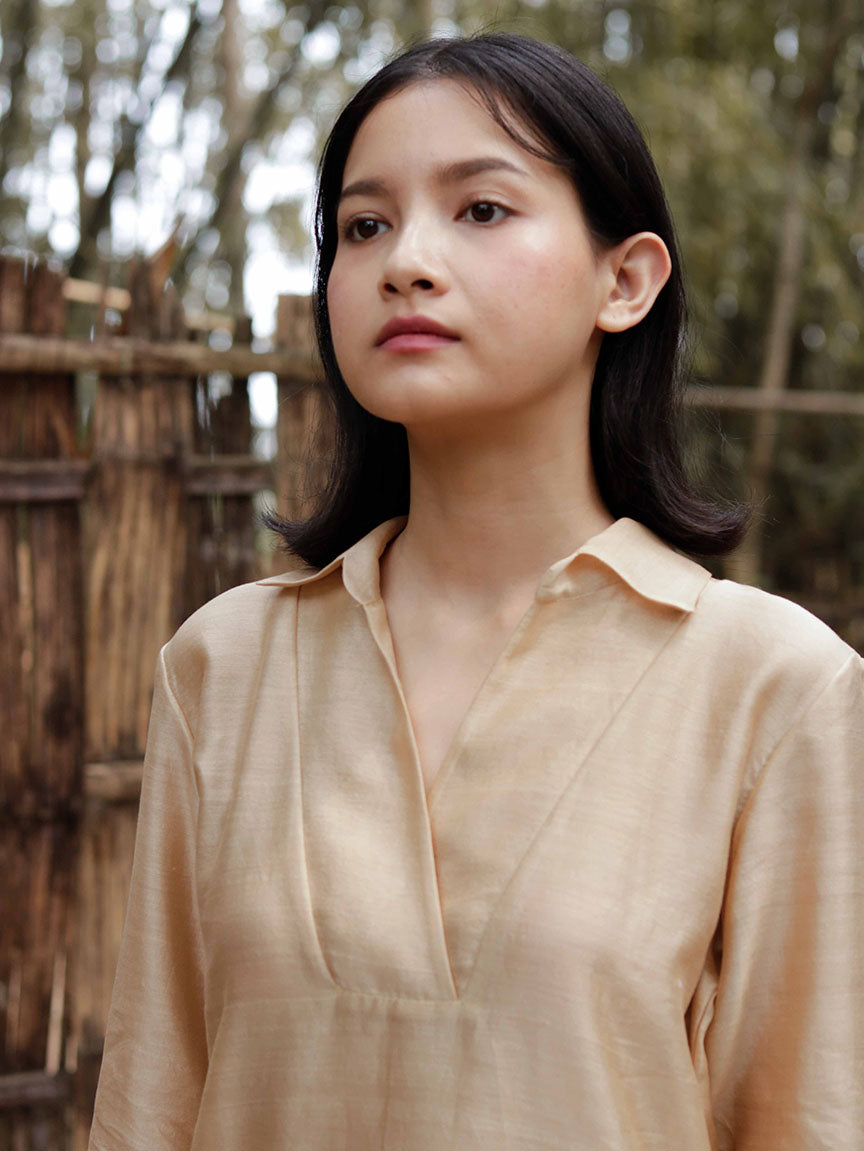 Long slip-on gold-beige easy shirt with box pleat at back & asymmetrical hem, Relaxed Fit, Shell Buttons, Tea dyed Handwoven Chanderi Silk fabric.