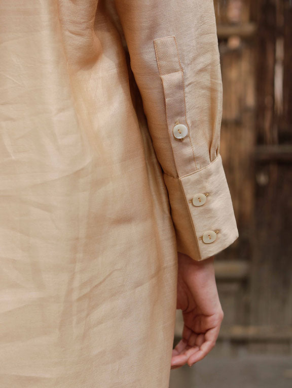Long slip-on gold-beige easy shirt with box pleat at back & asymmetrical hem, Relaxed Fit, Shell Buttons, Tea dyed Handwoven Chanderi Silk fabric.