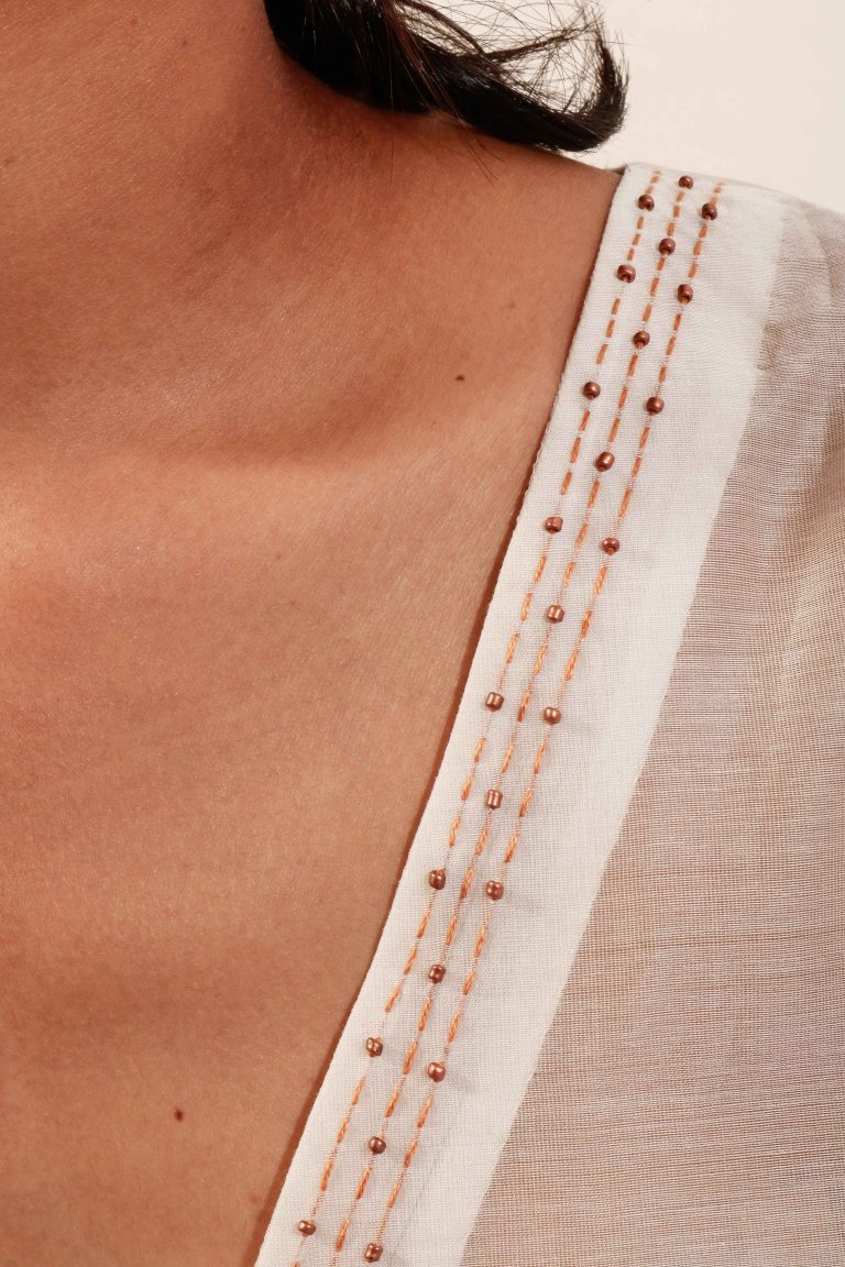 “V” Neck off-white translucent chanderi silk top with handcrafted embroidery and beadwork detail for women.