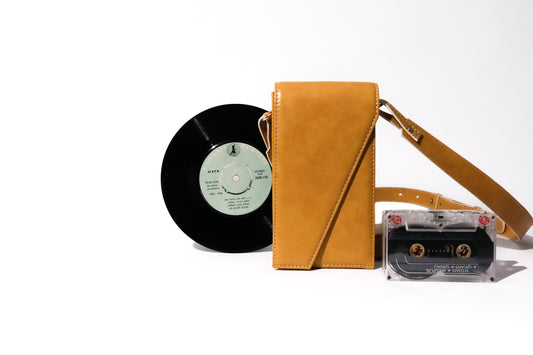 The record sling phone mustard made with conscious and vegan leather.